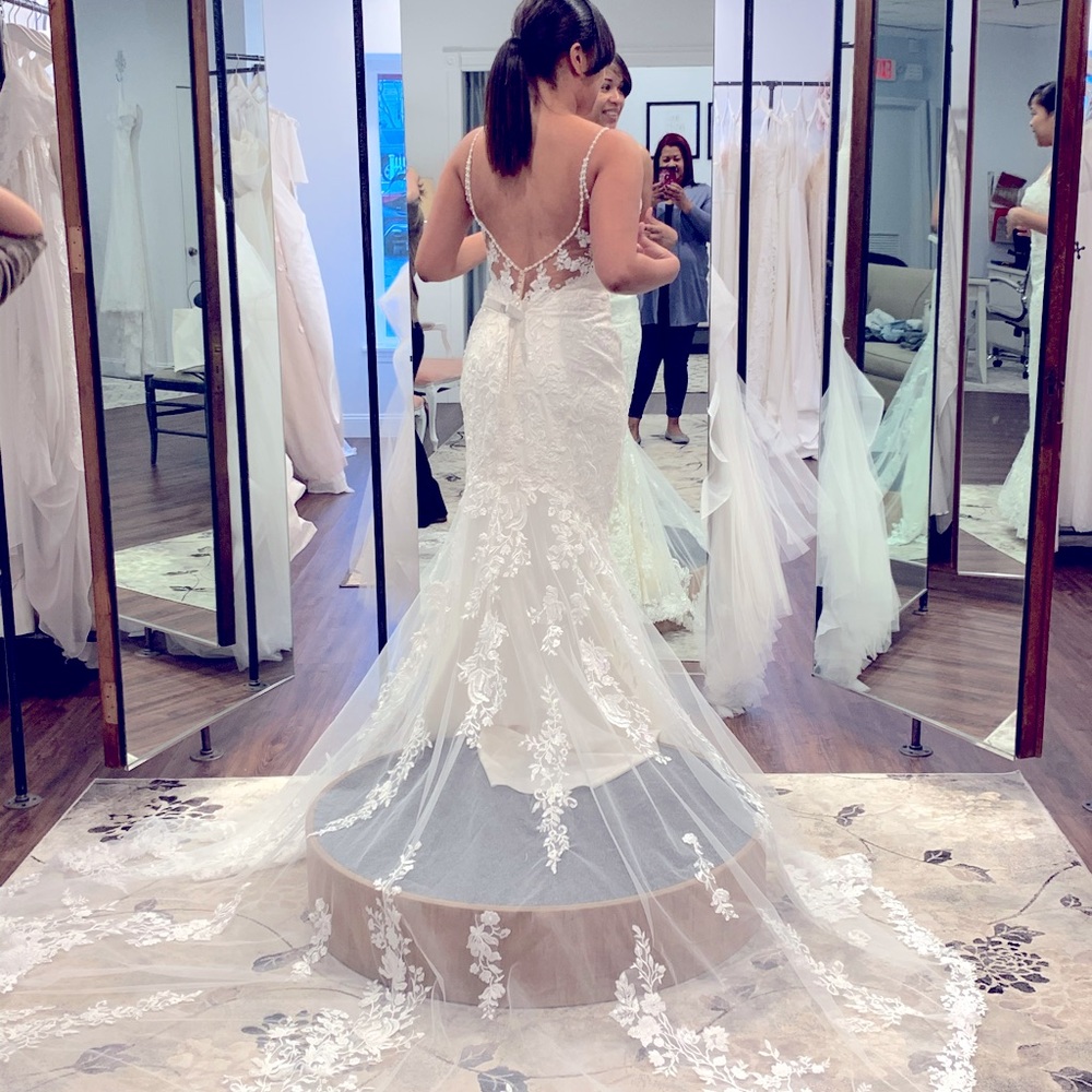 New, never worn ivory lace dress with bustle.